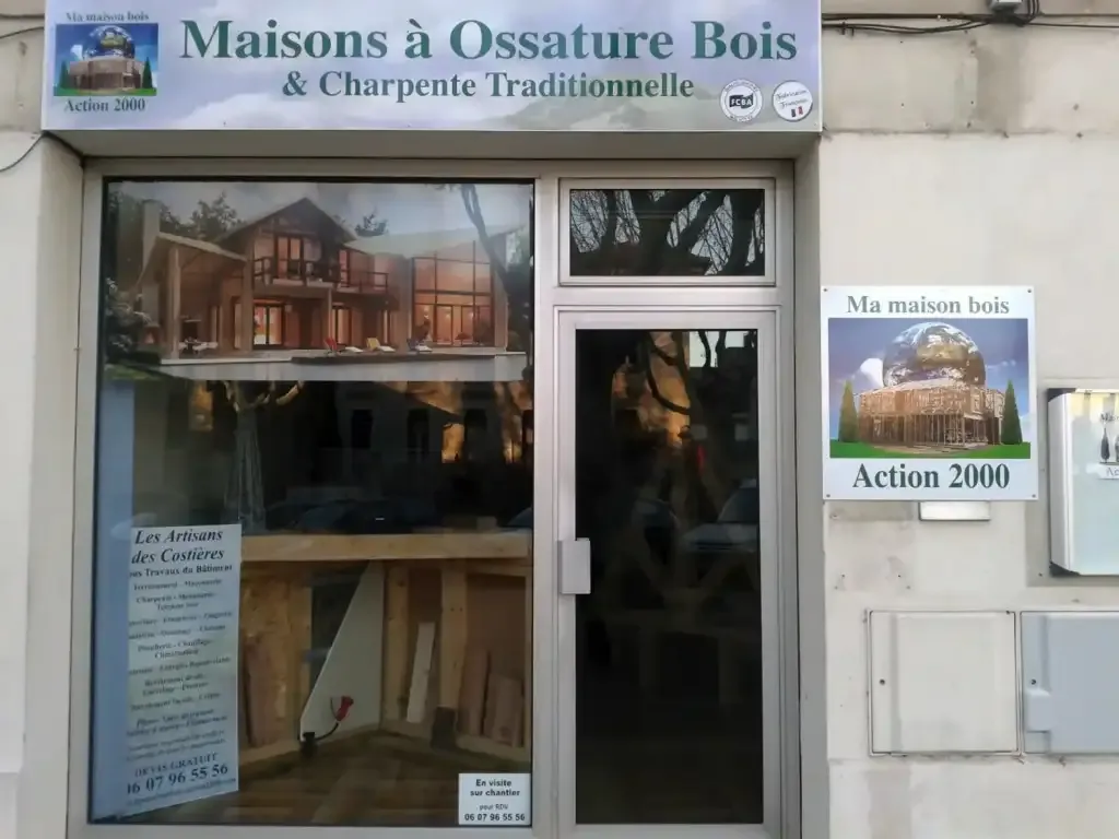 Devanture habillée d’une enseigne, d’une vitrine et de panneaux pour une entreprise de maisons en bois.