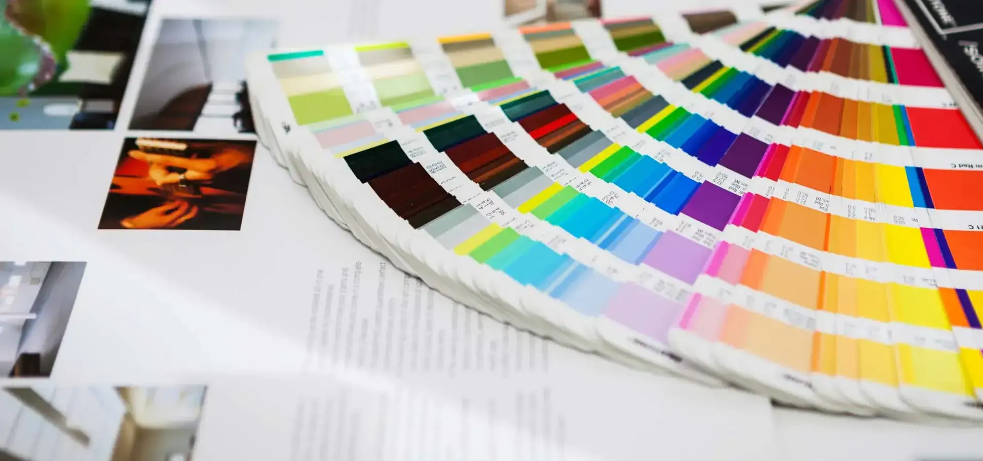 Nuancier de couleurs ouvert sur des supports imprimés dans un atelier graphique.