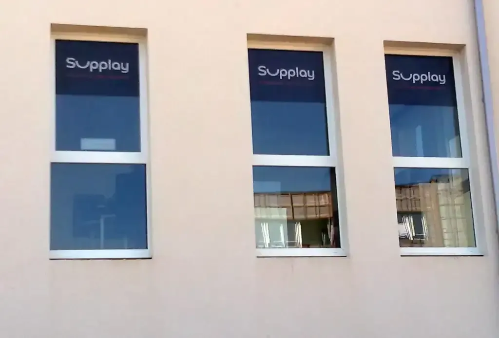 Publicité adhésive bleue et noire posée sur trois vitrages.