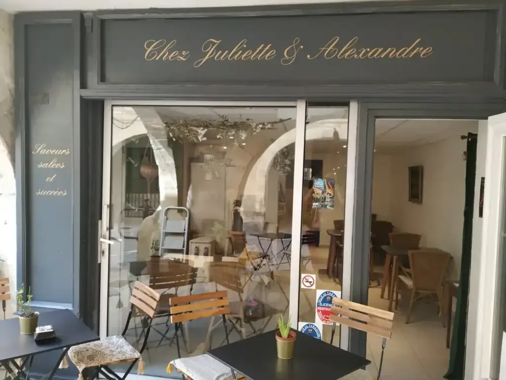 Lettrage doré sur la devanture gris foncé d’un café.